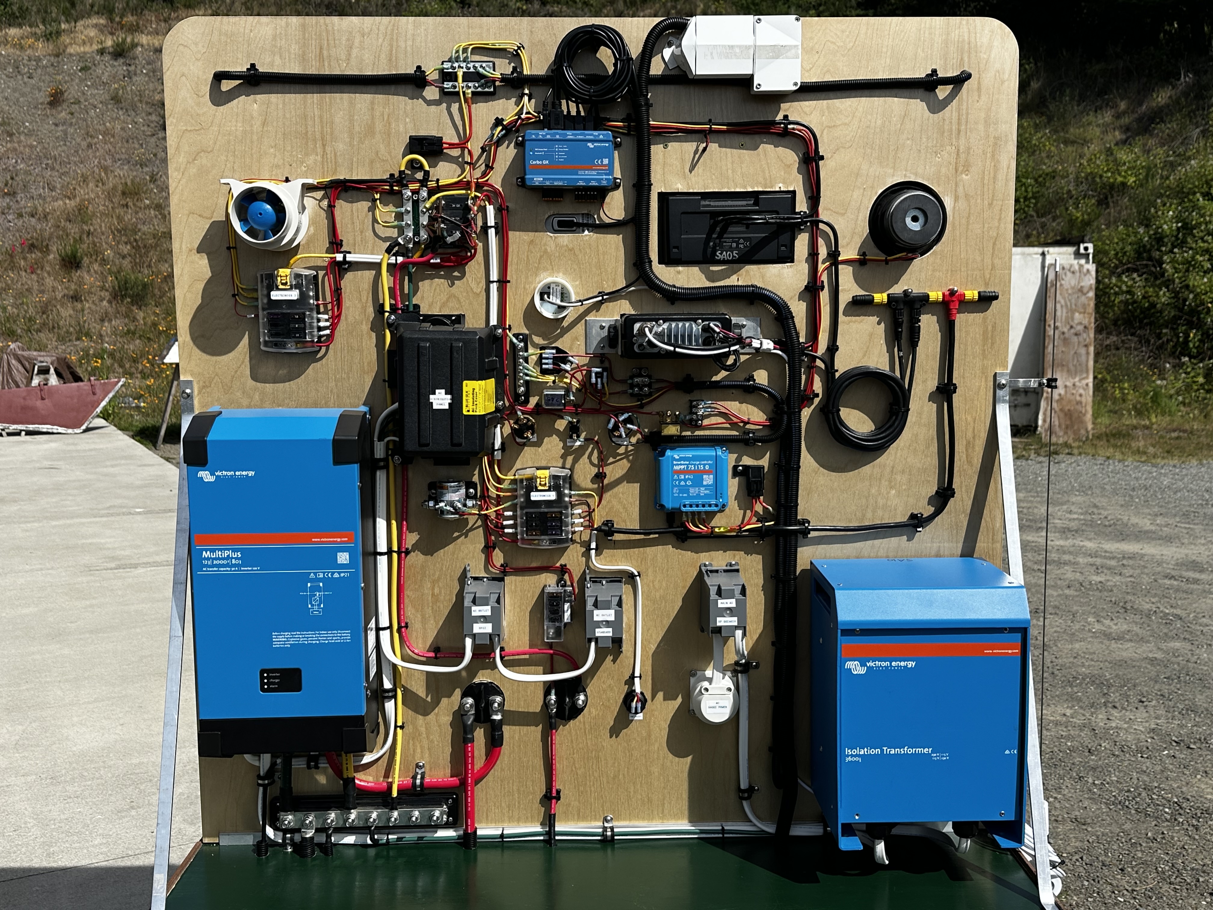 Systems side closeup showing Victron Multiplus inverter/charger, isolation transformer, Cerbo GX, MPPT charge controller, AC and DC distribution panels, and full conductor routing