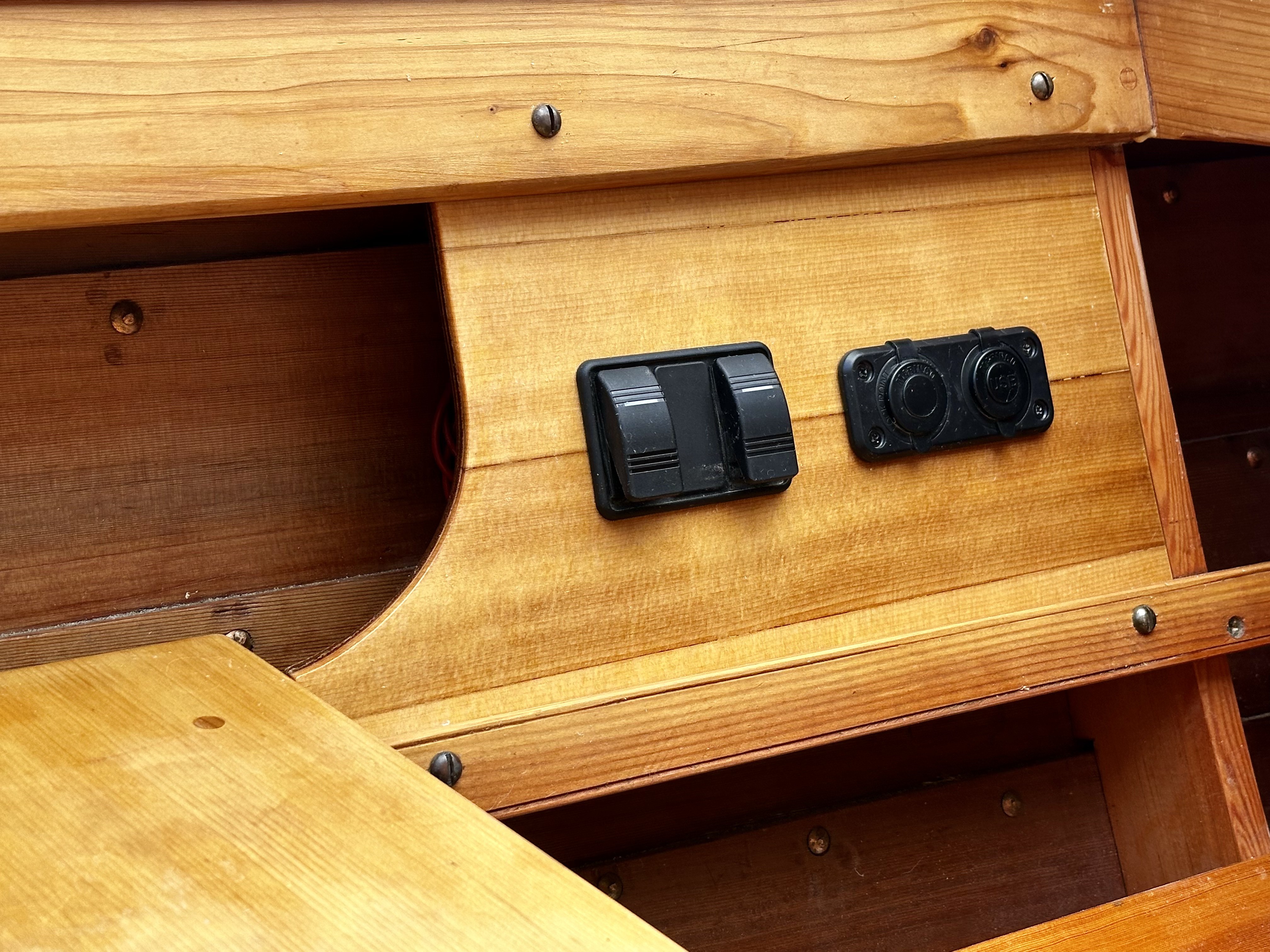 Rocker switches and dual USB charging outlets mounted flush in the custom wooden console panel